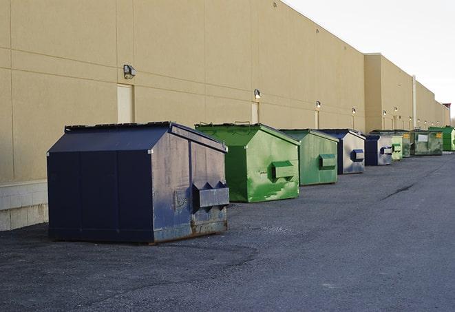 a series of colorful, utilitarian dumpsters deployed in a construction site in Cardington